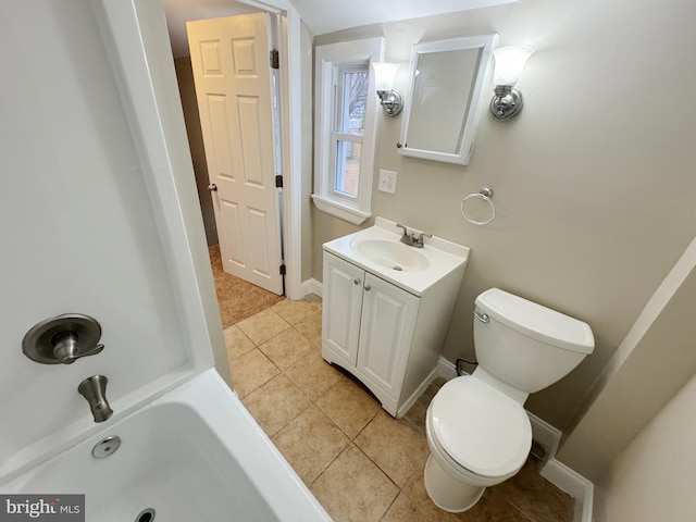 bathroom featuring toilet, vanity, tile patterned floors, and a washtub