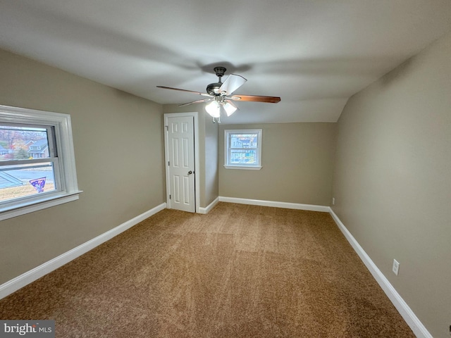 unfurnished bedroom with ceiling fan, light colored carpet, and lofted ceiling