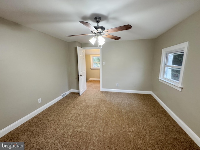 empty room with ceiling fan and light carpet