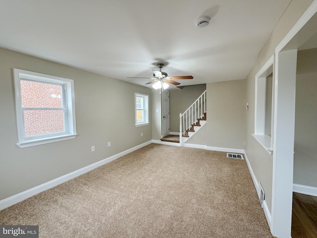 carpeted spare room with a wealth of natural light and ceiling fan