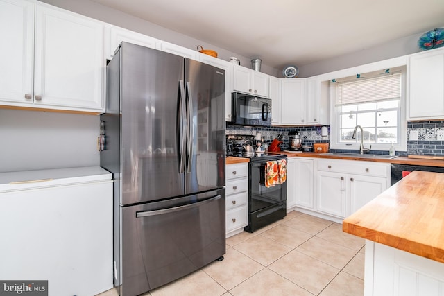 kitchen featuring backsplash, black appliances, white cabinets, sink, and butcher block countertops