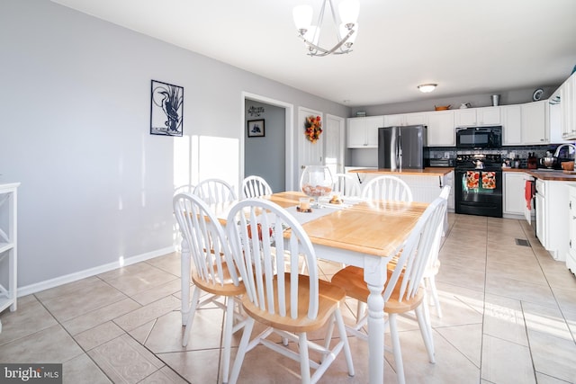 dining area with sink, light tile patterned floors, and a chandelier