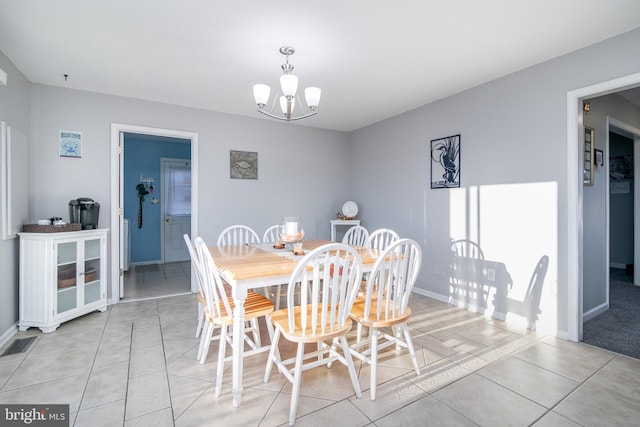 tiled dining space with a notable chandelier