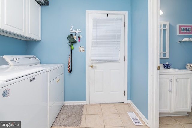 clothes washing area with light tile patterned floors, cabinets, and independent washer and dryer