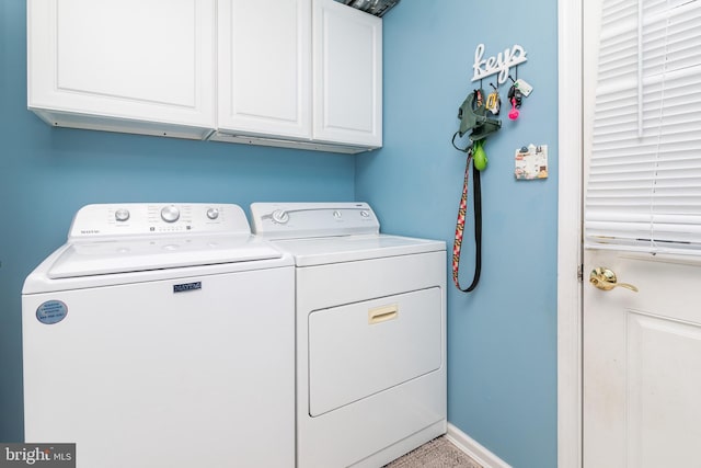 washroom with cabinets and washer and dryer