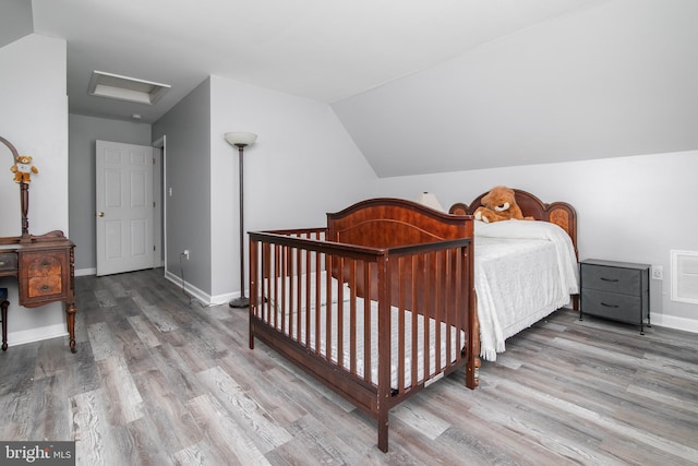 bedroom with lofted ceiling and light hardwood / wood-style flooring