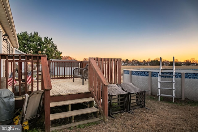 deck at dusk featuring area for grilling