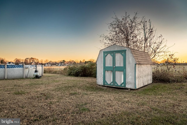 outdoor structure at dusk featuring a yard