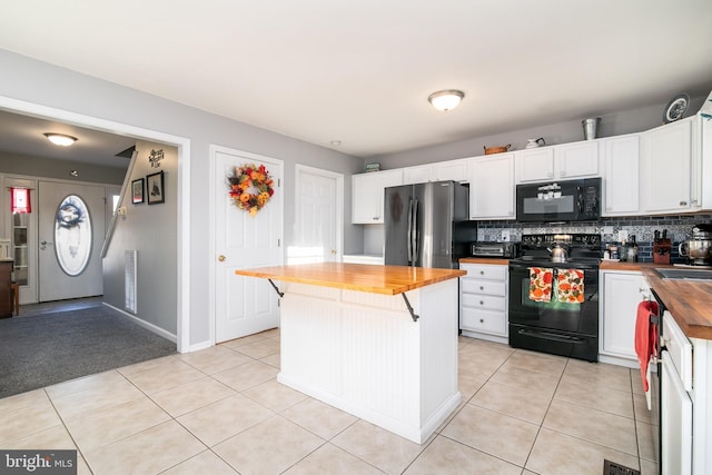 kitchen featuring butcher block countertops, white cabinetry, and black appliances