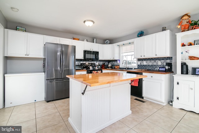 kitchen with black appliances, white cabinets, sink, butcher block countertops, and a kitchen island