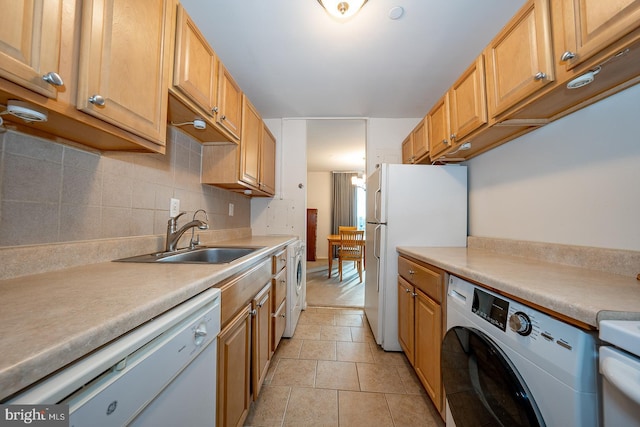 kitchen with sink, light tile patterned flooring, white appliances, and washer / dryer