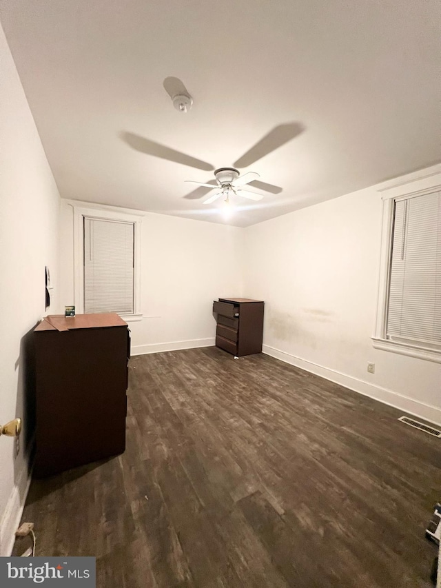 unfurnished bedroom with ceiling fan and dark hardwood / wood-style flooring