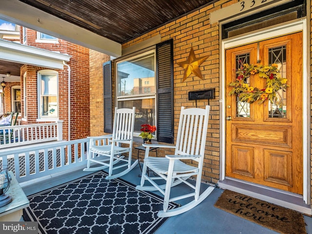 view of exterior entry featuring covered porch