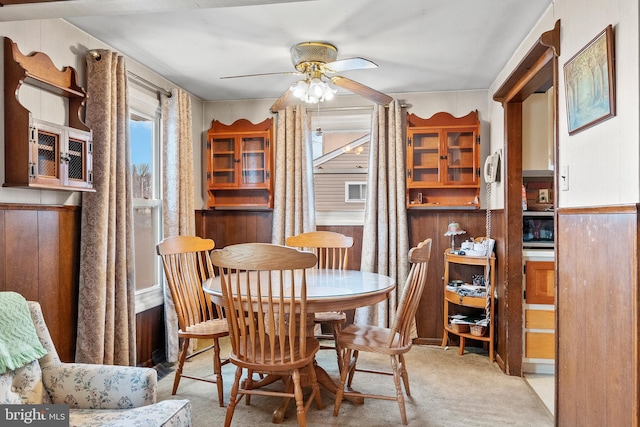 carpeted dining room with ceiling fan