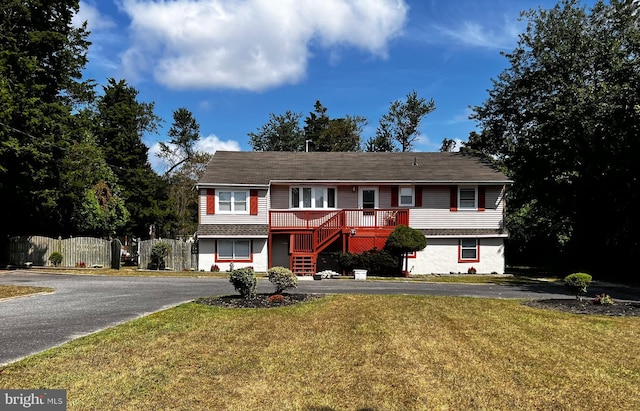 view of front of home with a deck and a front lawn