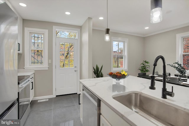 kitchen featuring pendant lighting, white cabinets, sink, light stone counters, and stainless steel appliances