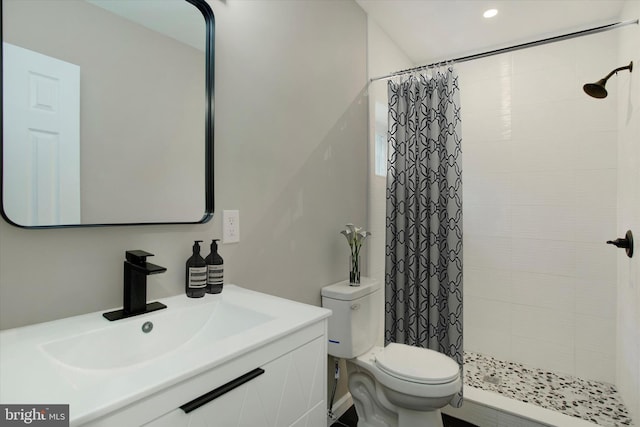 bathroom featuring curtained shower, vanity, and toilet