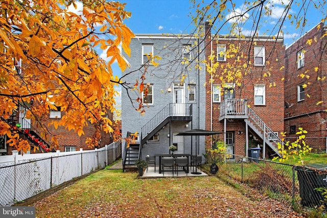 back of property with a patio area and a lawn