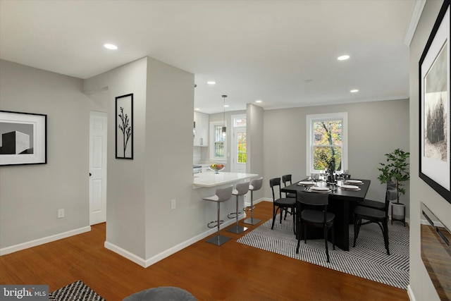 dining space with crown molding and hardwood / wood-style floors