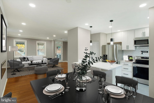 dining space with crown molding and dark hardwood / wood-style flooring