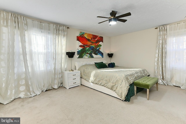 carpeted bedroom with a textured ceiling and ceiling fan