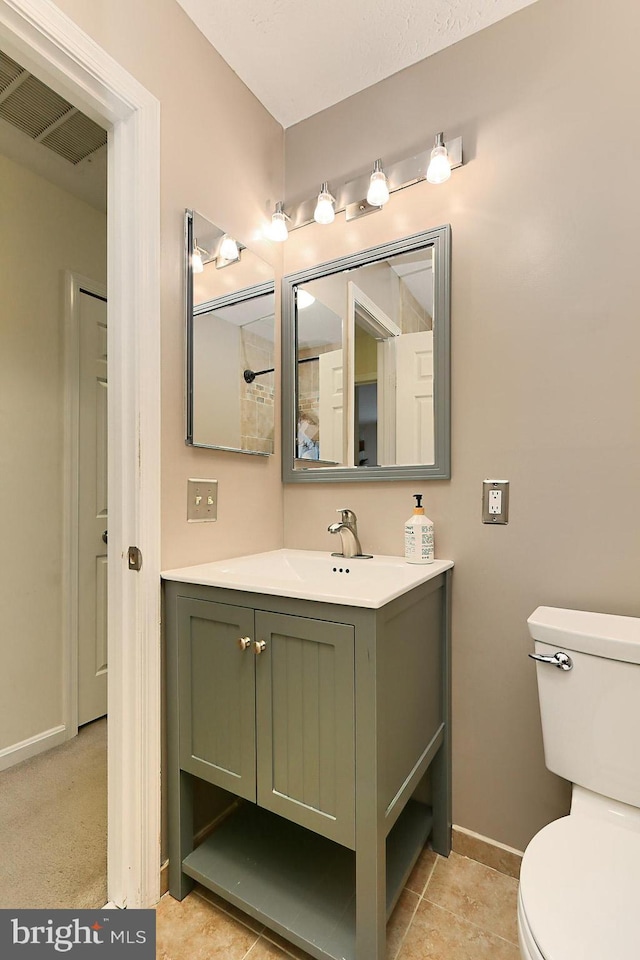 bathroom featuring tile patterned flooring, vanity, and toilet