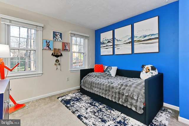 carpeted bedroom featuring multiple windows and a textured ceiling