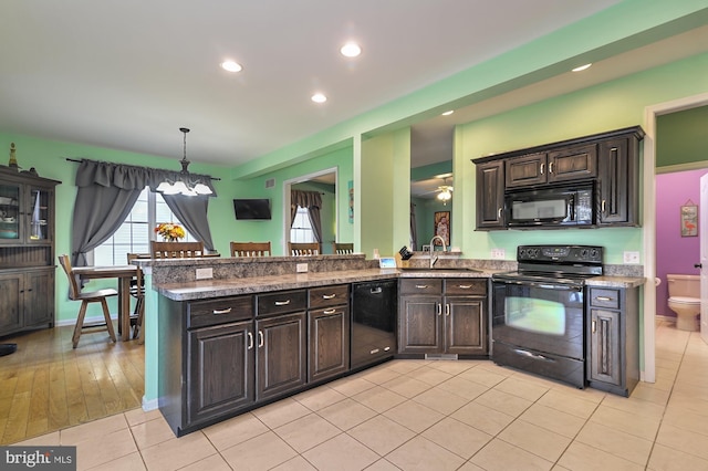 143 Mayor Ln, Felton, DE 19943 - kitchen featuring black appliances, light tile patterned floors, recessed lighting, dark brown cabinets, and hanging light fixtures