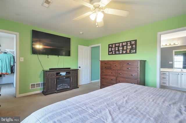 143 Mayor Ln, Felton, DE 19943 - carpeted bedroom featuring a walk in closet, connected bathroom, a ceiling fan, and a closet