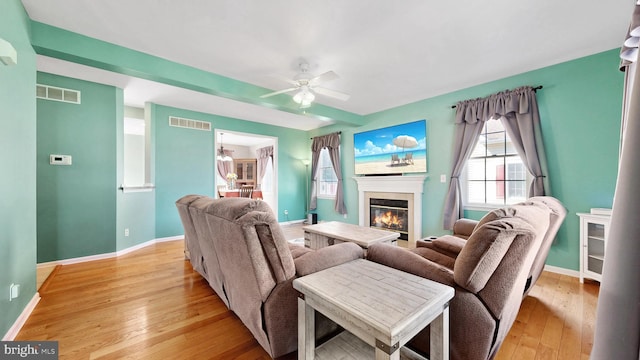143 Mayor Ln, Felton, DE 19943 - living room featuring a glass covered fireplace, a ceiling fan, and light wood finished floors