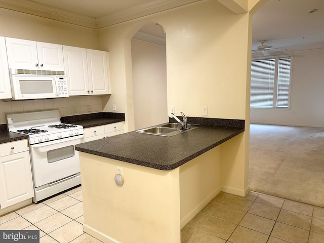 kitchen with white appliances, light carpet, sink, white cabinetry, and kitchen peninsula