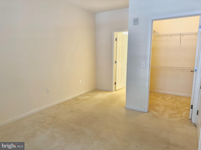 unfurnished bedroom with light colored carpet and a closet