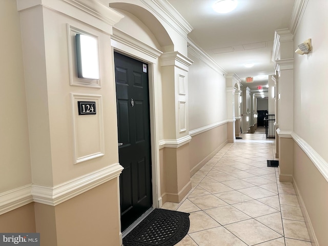 hall featuring light tile patterned floors and ornamental molding