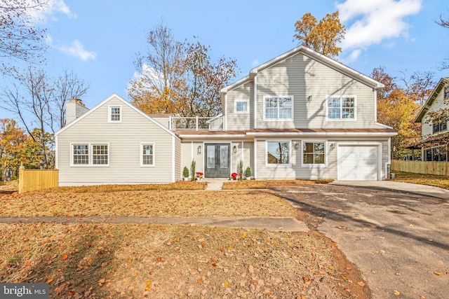 rear view of house featuring french doors, a balcony, and a garage