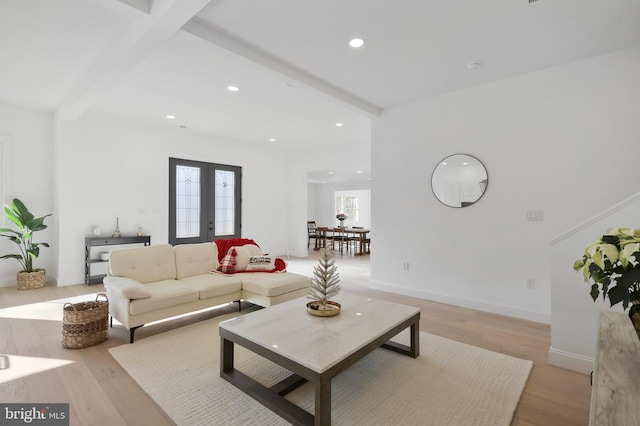 living room with french doors, beamed ceiling, and light wood-type flooring