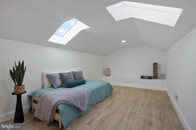 bedroom featuring light wood-type flooring and vaulted ceiling with skylight