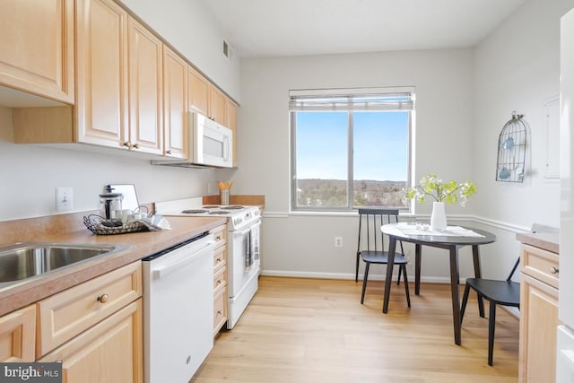 kitchen featuring light brown cabinetry, white appliances, and light hardwood / wood-style flooring