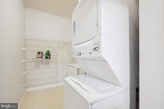 washroom featuring stacked washer / drying machine