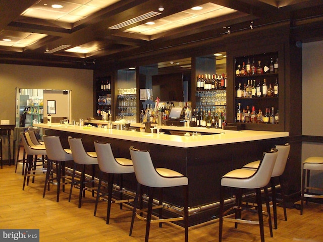 bar featuring light hardwood / wood-style floors and coffered ceiling