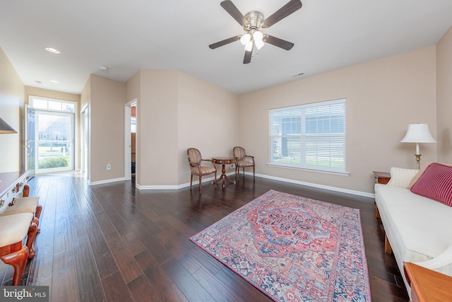 living area with ceiling fan and dark hardwood / wood-style flooring