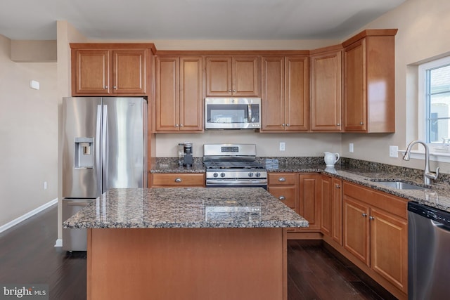 kitchen featuring a center island, sink, stainless steel appliances, and dark wood-type flooring