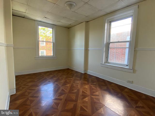 spare room with dark parquet floors