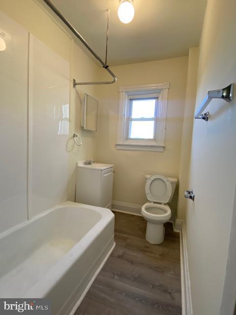 bathroom with toilet and wood-type flooring