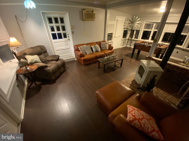 living room with wood-type flooring, a wall mounted AC, and a wood stove