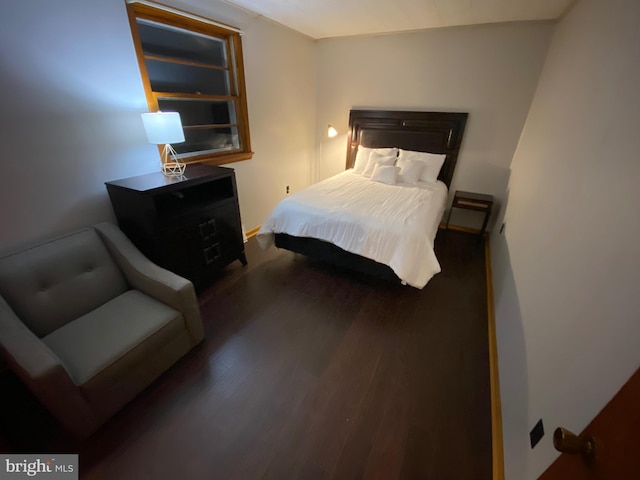 bedroom with dark hardwood / wood-style floors