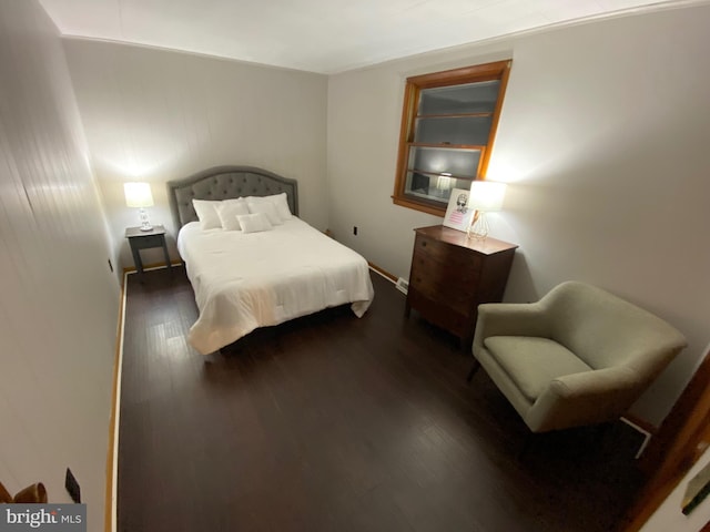 bedroom with dark hardwood / wood-style flooring