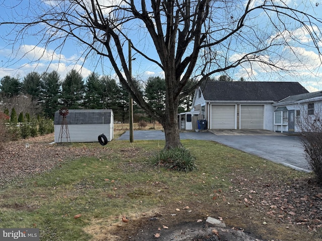 view of yard with a storage unit and a garage