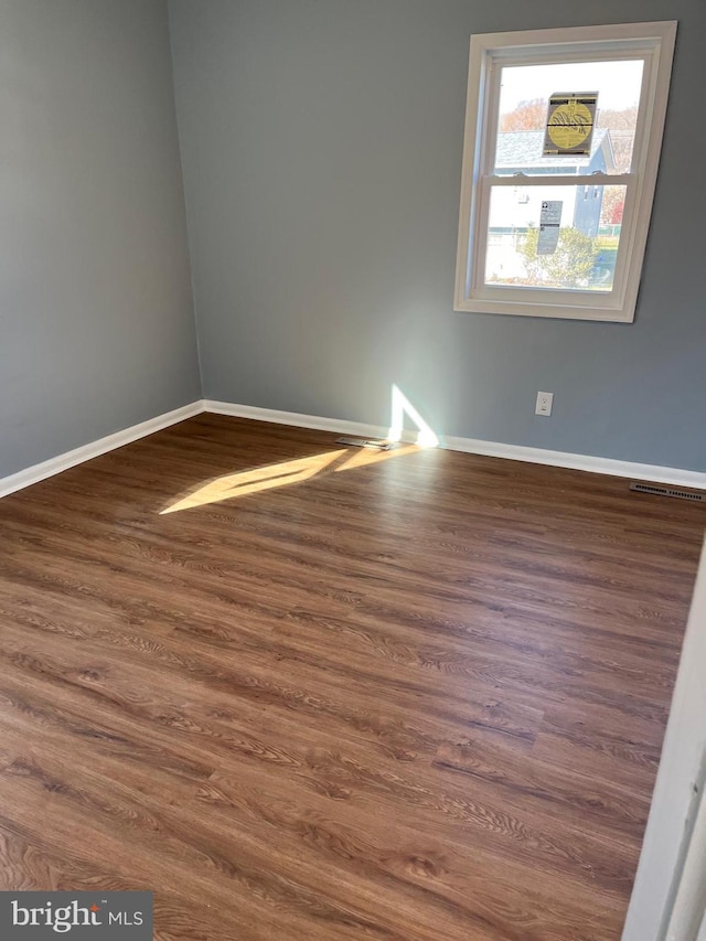 empty room with dark hardwood / wood-style flooring