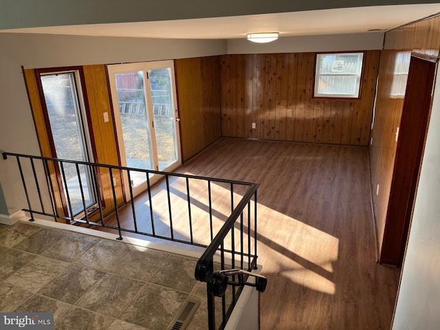 spare room with dark hardwood / wood-style floors, vaulted ceiling, and wooden walls