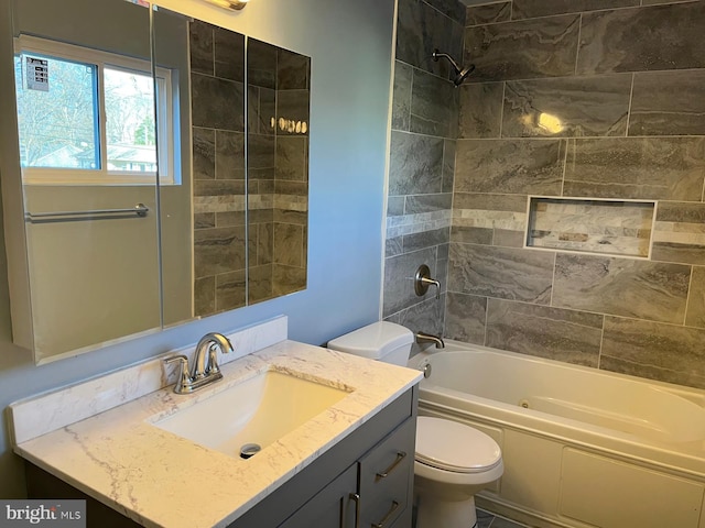 full bathroom featuring vanity, tiled shower / bath combo, and toilet